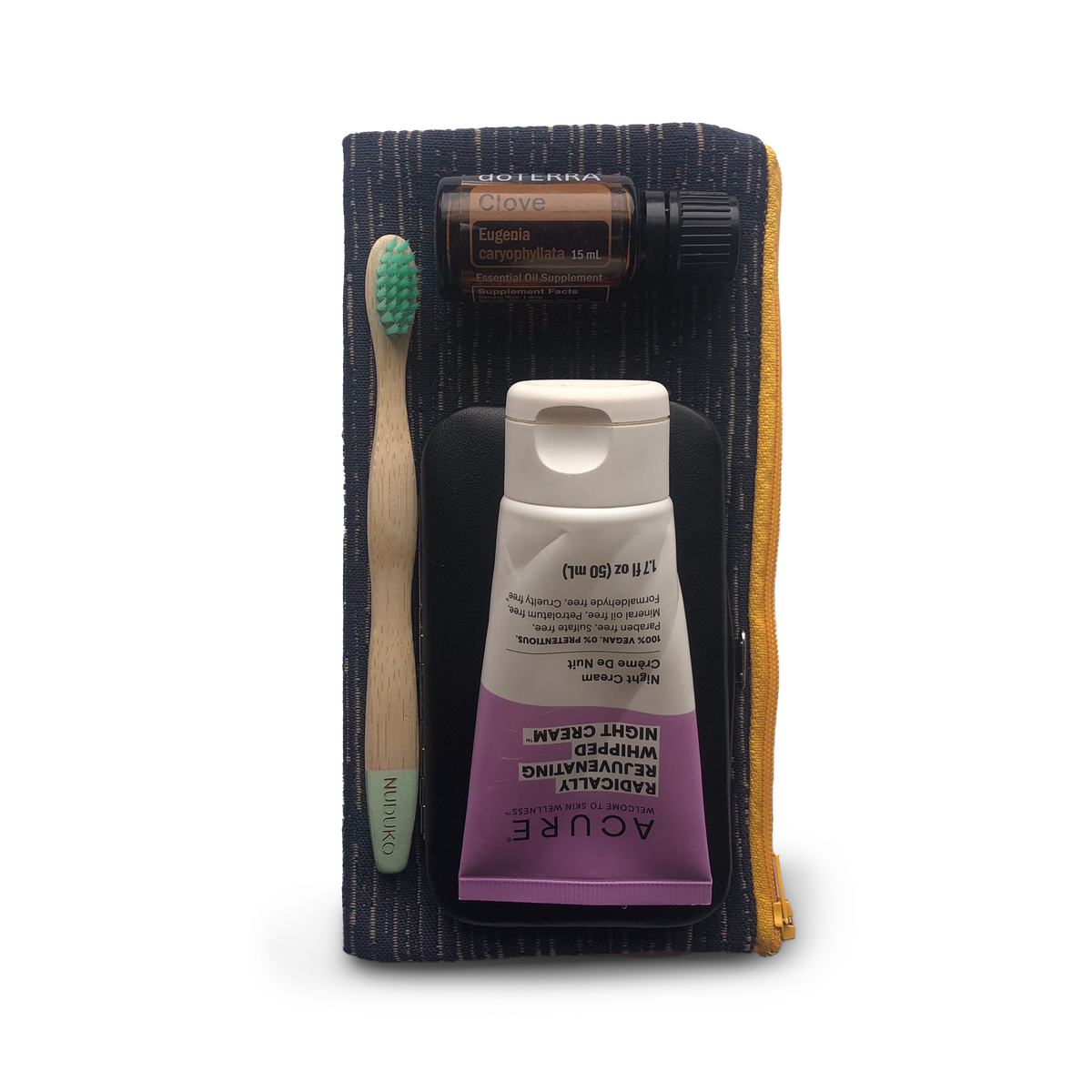 Set of skincare products including a tube, brush, and bottle on a white background
